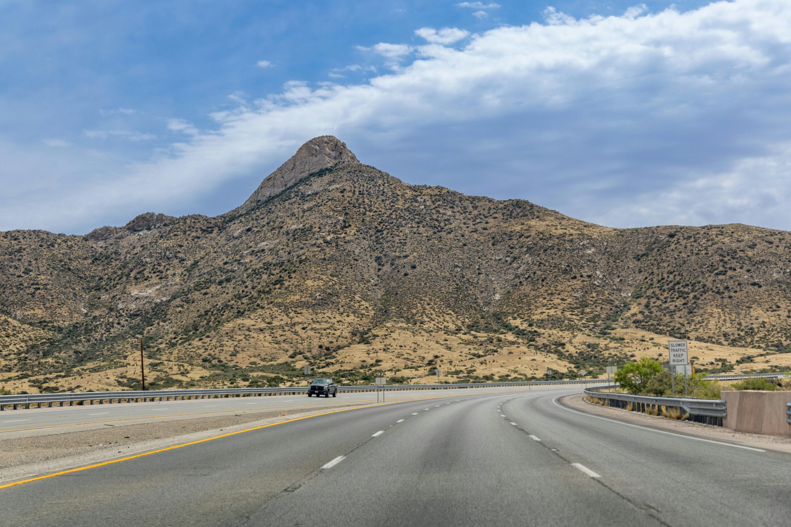 Desert highway leading to rugged hills under a clear sky in El Paso, Texas.
